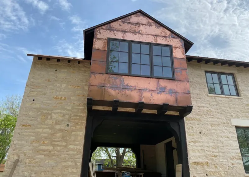 Copper metal panel facade on a stone building for Metal Roof Coating in Earl